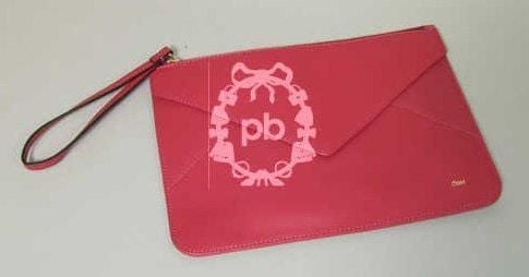 POCHETTE en cuir framboise, fermeture éclair munie d'une dragonne, poche frontale à rabat (excellent état)