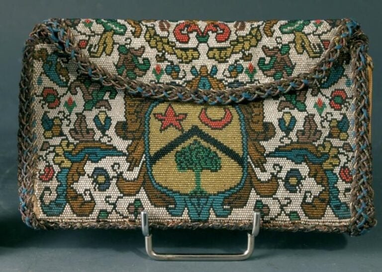 Pochette en perlé à décor de rinceaux et fleurettes stylisées entourant un écusson libanais orné d'un cèdre vert surmonté d'un chevron noir, d'une étoile rouge et d'un croissant roug