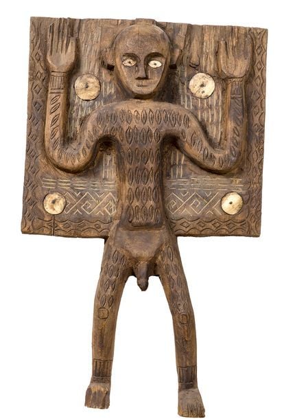Porte de crypte funéraire avec personnage aux bras levés sculpté en haut-relief à décor gravé et incrustations de coquillage
