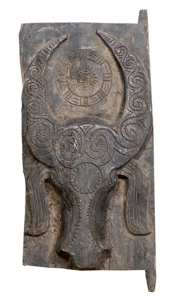 Porte en bois sculpté et gravé à décor de tête de buffle et motifs stylisés entre les corne