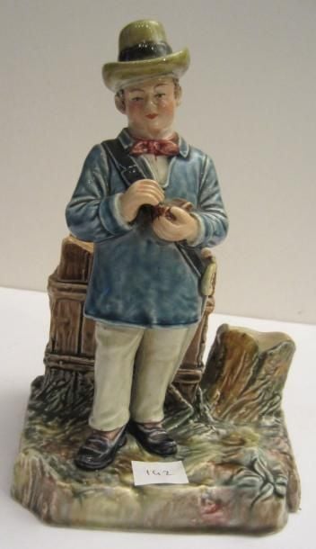 Pot à tabac pyrogène en terre cuite polychrome représentant un garde champêtre ouvrant une blague à taba