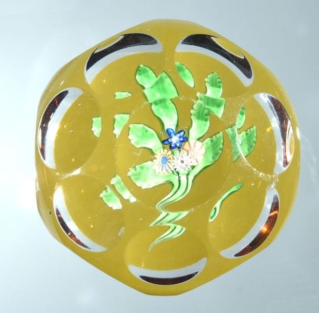 Presse-papiers à fond ambre orné d'un bouquet composé de quatre bonbons polychromes sur cinq feuilles verte