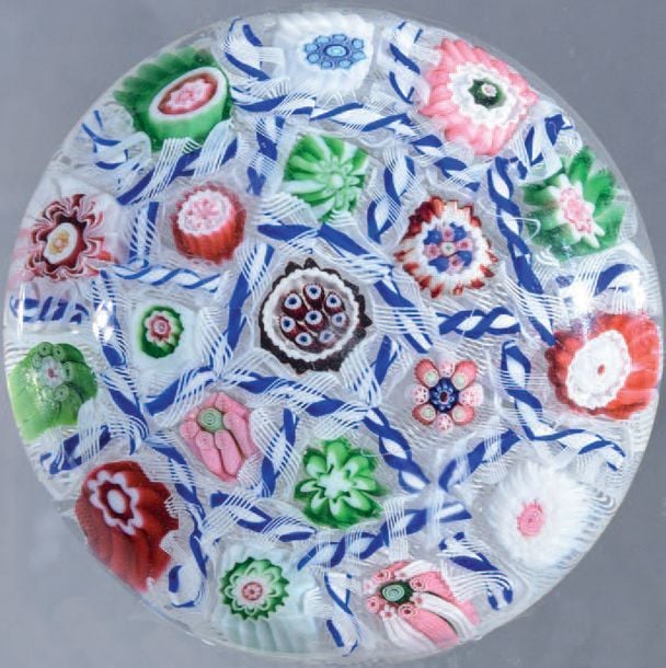 Presse-papiers à fond de torsades blanches filigranées orné de dix-neuf bonbons polychromes séparés par des torsades rubanées et filigranées blanches et bleue