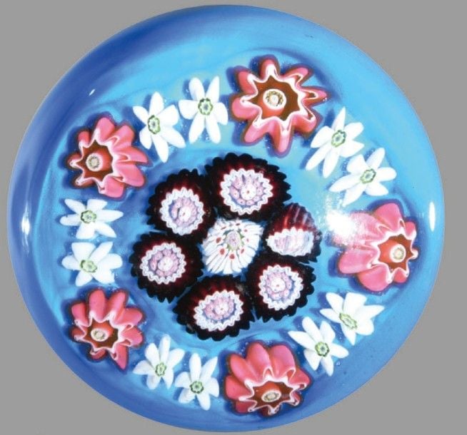 Presse-papiers à fond turquoise orné de deux cercles, l'un composé de cinq bonbons roses et de dix étoiles blanches, le second de six bonbons violets et polychromes autour d'un motif central de huit étoiles blanches à coeur rose et une rose cachée rose et verte central