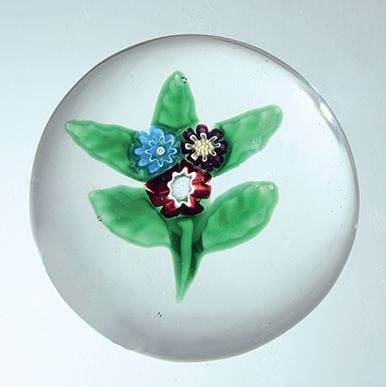 Presse-papiers à motif bouquet composé de trois bonbons (un turquoise, un violet et un rouge) sur une tige verte portant cinq feuille