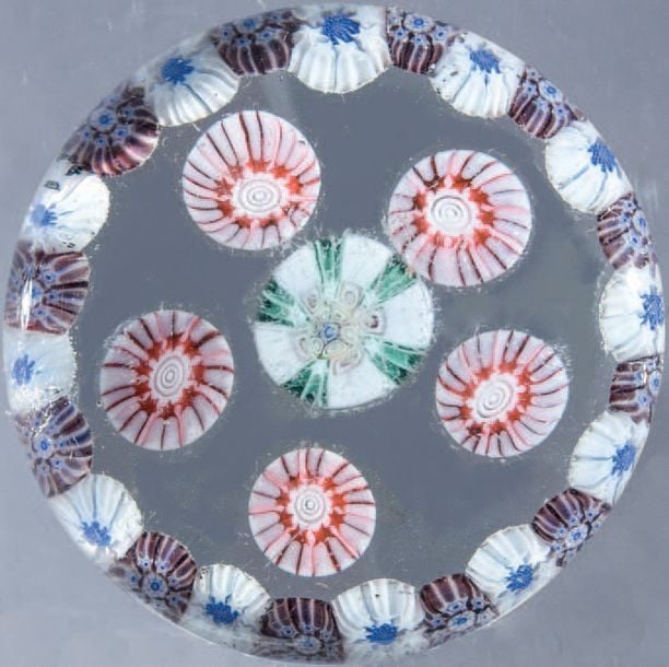 Presse-papiers à motif de cercle périphérique composé de bonbons violets alternés de bonbons blancs étoilés, entourant cinq bonbons roses et un bonbon central vert et blan