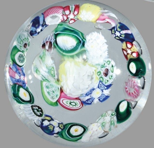 Presse-papiers à motif de deux cercles concentriques de bonbons polychromes, dont deux à rose cachée blanche, autour d'un motif central blan