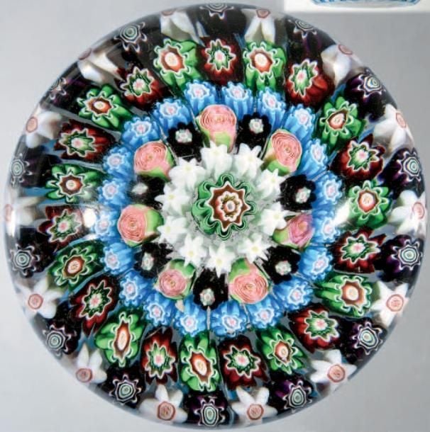 Presse-papiers à motif de millefiori composé de six cercles concentriques de bonbons polychromes (dont sept roses vertes et roses) organisés autour d'un bonbon central vert, blanc et rouge; panier de cannes turquoise alternées de cannes blanches (fêlure de rétraction latérale peu visible
