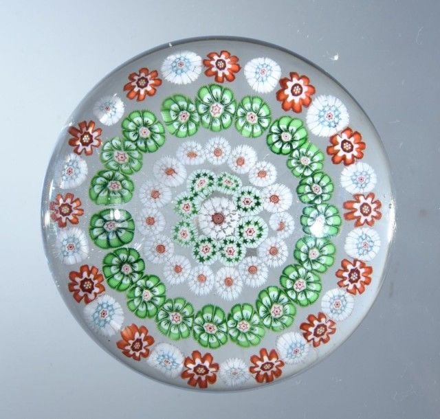 Presse-papiers à motif de quatre cercles concentriques de bonbons polychromes dont un formé de bonbons verts et blancs à fléchettes vertes et un cercle de bonbons blancs à étoiles vertes autour d'un bonbon central blanc étoil