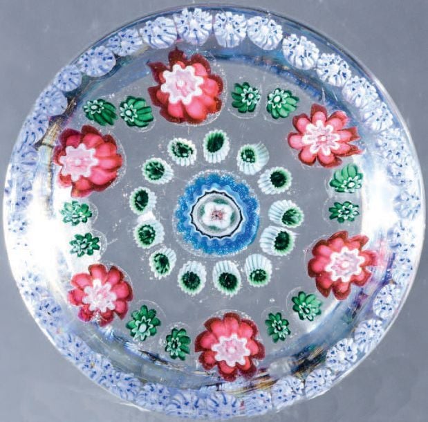 Presse-papiers à motif de trois cercles concentriques, en périphérie bonbons bleus et blancs, en deuxième six bonbons roses et douze petits bonbons verts, en troisième treize bonbons verts et blancs, autour d'un bonbon central bleu, blanc et ros