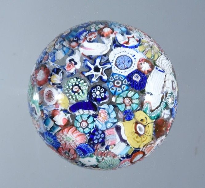 Presse-papiers à motif en dôme de millefiori de bonbons polychromes, dont une rose blanche et verte, présentés en pêle-mêl