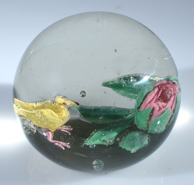 Presse-papiers en verre à décor en trois dimensions représentant un oiseau jaune devant un bouton de rose rose et ver