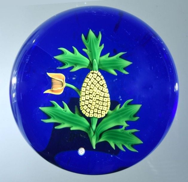 Presse-papiers signé et daté B 1983, à fond bleu translucide orné d'un ananas et d'une fleu