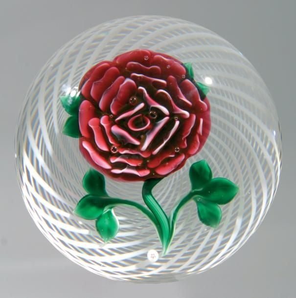 Presse-papiers signé et daté B 1990, à fond de latticino blanc spiralé orné d'une rose sur une tige vert