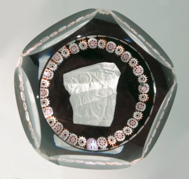 Presse-papiers signé et daté SL 1975, à fond rouge orné d'un cristallo-cérame représentant un chapiteau de la cathédrale d'Autun entouré d'une couronne de bonbons polychromes alterné