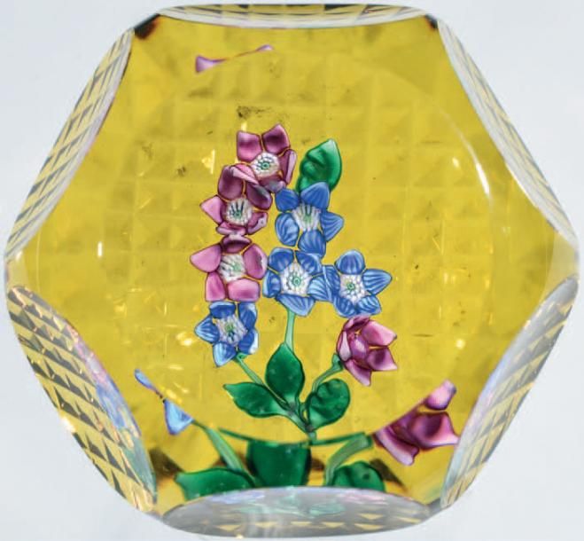Presse-papiers signé et daté SL 1979, à fond ambre orné de quatre fleurettes bleues et quatre fleurettes rose