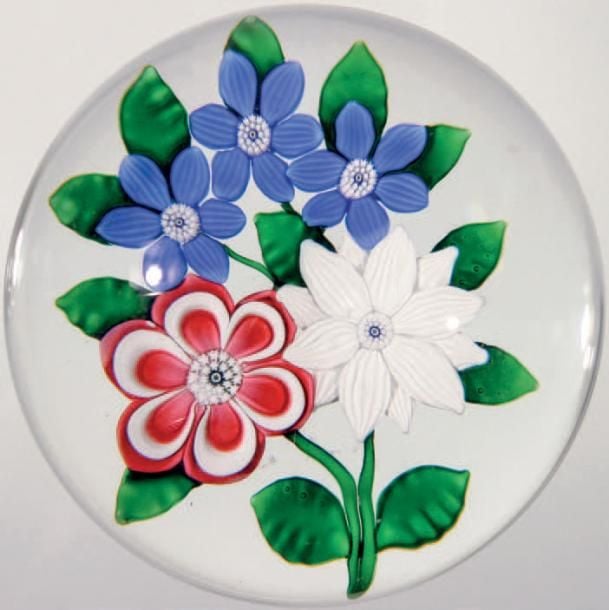 Presse-papiers signé et daté SL 1986, à motif de bouquet tricolore composé d'une primevère rose et blanche, d'une double clématite blanche et de trois clématites bleue