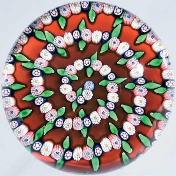 Presse-papiers signé et daté SL 1988, à fond rouge opaque orné d'une spirale composée de bonbons polychromes et de feuilles verte