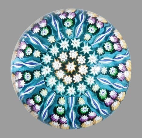 Presse-papiers signé P, à fond sablé vert, orné de onze quartiers de six bonbons polychromes; motif central de deux cercles de bonbons autour d'un bonbon centra
