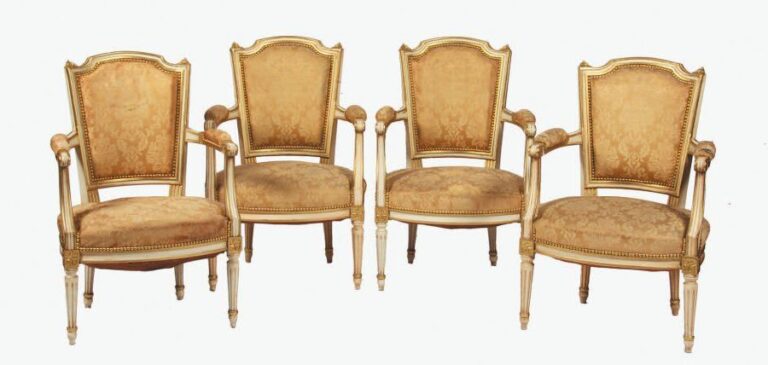 Quatre fauteuils en bois sculpté, mouluré, relaqué blanc et or, à dossier chapea