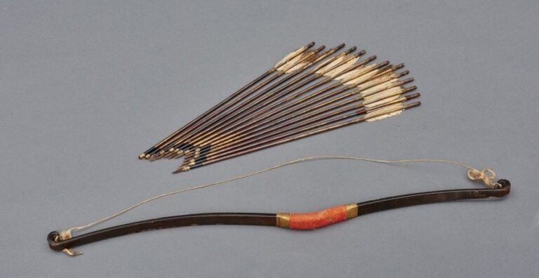 Rare arc en bois avec treize flèches (dotées pour la plupart de pointes de métal