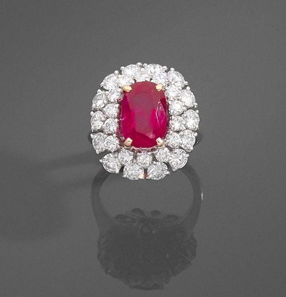 •Rare BAGUE en platine (950‰) et or gris (750‰) serti d'un rubis BIRMAN, NON CHAUFFE de forme coussin pesant 5,29 carats dans un double entourage de diamants taille brillan