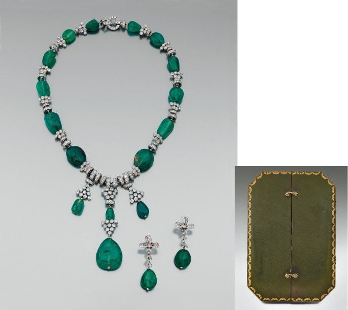 Rare COLLIER en platine et or gris, articulé, composé d'importantes perles d'émeraudes alternées de coulants circulaires et motifs « grappes » en platine entièrement serti de diamants ronds, retenant en pampille quatre gouttes d'émeraudes dont une plus important