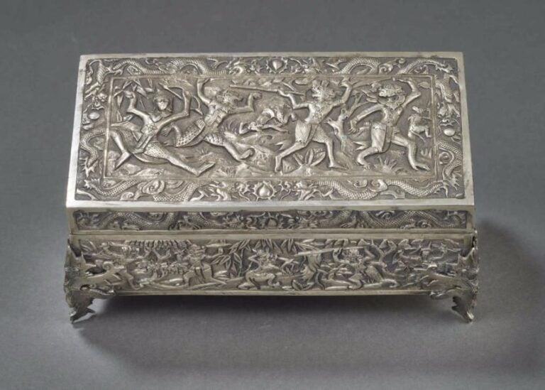 RAVISSANT COFFRET A BIJOUX QUADRIPODE EN ARGENT ORNE DE LA BATAILLE DE LANKA Inde du Sud ou Siam, Circa 1900 De forme rectangulaire et à couvercle, il repose sur quatre pieds appliqués formant garud
