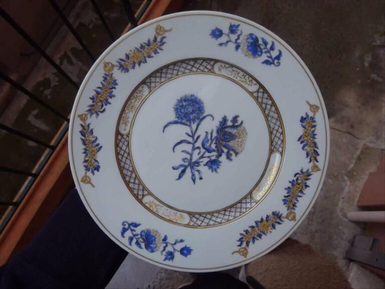 RAYNAUD LIMOGES Partie de service à dîner en porcelaine à décor de chardons émaillé bleu et or, modèle "Lalique" réalisé d'après un modèle connu d'assiettes de la période Yong-Tcheng (Yongzheng 1723-1735