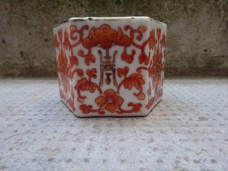 RINCE-PINCEAUX HEXAGONAL EN PORCELAINE A DECOR ROUGE DE FER DE TROIS LONGEVITES ET DE TROIS BONHEURS° Chine, Epoque XXe siècle A decor emaillé continu d'une alternance de chauves-souris (symboles de bonheur) et de caractères shou (symboles de longevité) sur fond de rinceaux feuillagés et fleuris de lotu