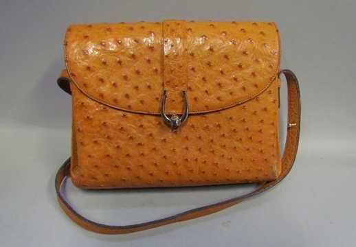 SAC à soufflets en autruche gold, fermoir pivotant rehaussé d'un fer à cheval, anse bandoulière transformable (petite patine d'usage aux coins)