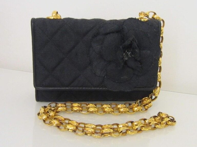 SAC en tissus noir matelassé gansé de cuir, orné d’une fleur «camélia