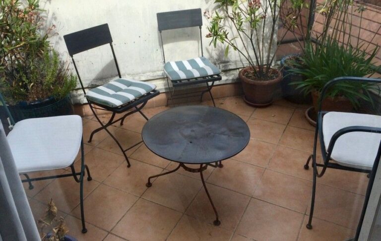 Salon de jardin en fer forgé : table basse, un fauteuil et trois chaise