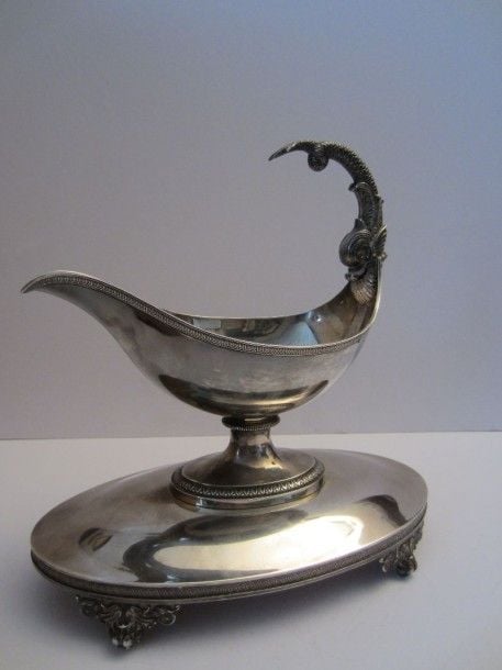 Saucière sur piédouche en argent, bordure d'oves et palmettes; la prise en forme de dauphi