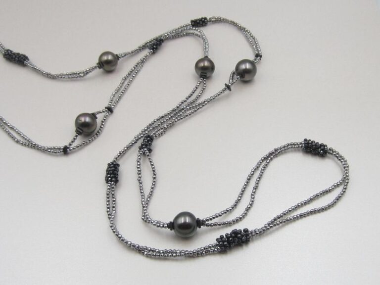 SAUTOIR composé de deux rangs de perles facettées d'hématite alternées de six perles de culture grises de Tahit
