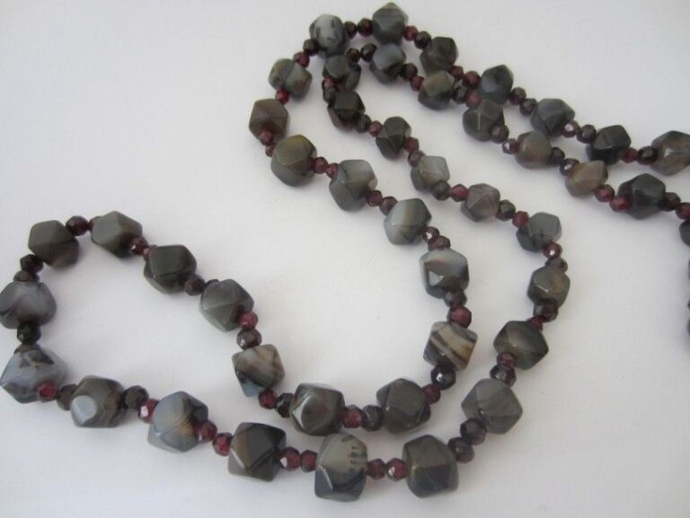 SAUTOIR composé de perles facettées d?agates grises et pierres rouges alternée