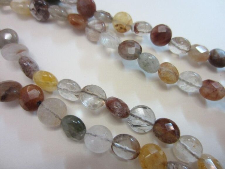 SAUTOIR composé de perles rondes facettées et aplaties de quartz rutilé et pierres dures de différentes couleur