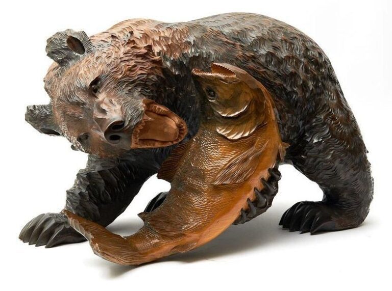 Sculpture en bois reprèsentant un ours jouant avec un gros saumo