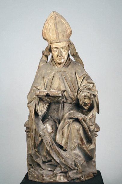 Sculpture en bois sculpté représentant un évêque tenant une bible de la main droit