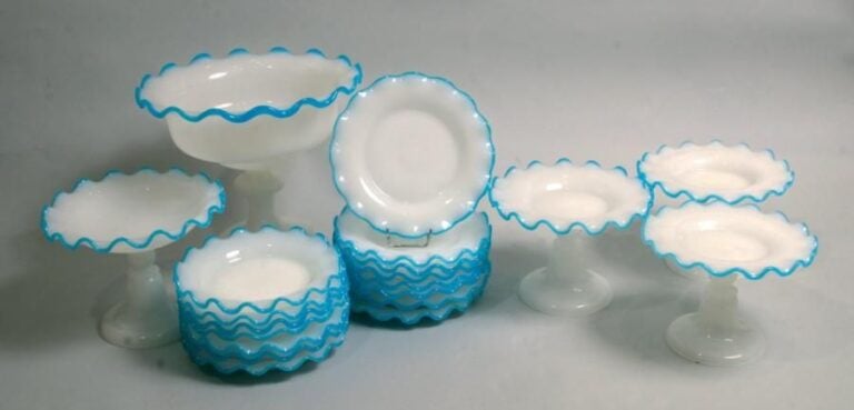 Service à dessert comprenant quatorze assiettes, un compotier sur pied et trois présentoirs et une grande coupe sur pied, en opaline pâte de riz à bord godronné orné d'un filet d'opaline bleue (un éclat