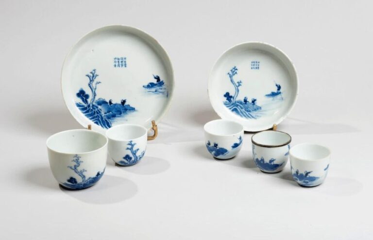 Service à thé comprenant quatre bols et deux coupes en porcelaine décorée en bleu sous couverte d'un lettré dans une barque et deux lettrés sur une falaise surmontés de poèm