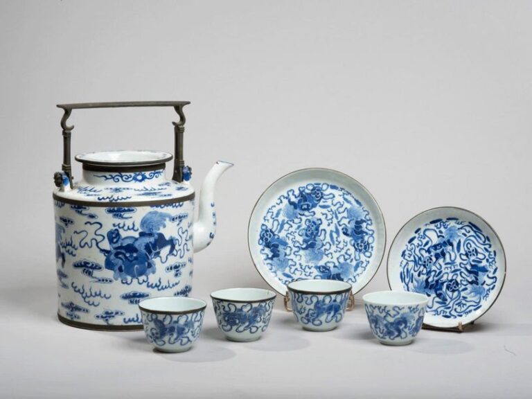 Service à thé de sept pièces comprenant une verseuse, deux coupes, et quatre sorbets en porcelaine décorée en bleu sous couverte de chimères jouant avec des balles de ruba