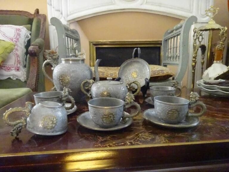 SERVICE A THE EN ETAIN  Vietnam, Epoque XXe siècle En étain et à rehauts dorés, aux anses dragons et à décor de fleurs de prunus et de caractères Fu (bonheur
