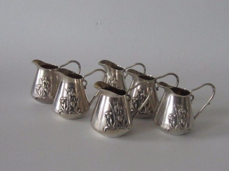 Service art nouveau composé de 6 petits pichets individuels en argent à décor en applique de perce-neig