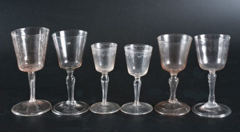 Six verres de fougère à pied et coupe tronconique en verre soufflé dont deux gravés d'une guirlande de fleur