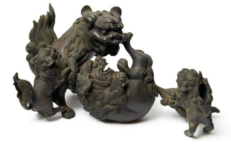 Statue en bronze de couleur foncèe reprèsentant un groupe de lions gardiens de temple (shishi), deux adultes ainsi que deux plus jeunes personnages jouant entre eu