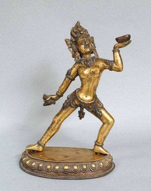Statuette de daikini debout dansant sur un double lotus, en bronze doré tenant le karttrka et la kalas