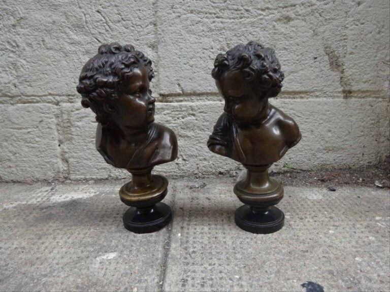 Suite de deux petits BUSTES d'enfants (de putti) en bronze à patine brune, l'un monogrammé