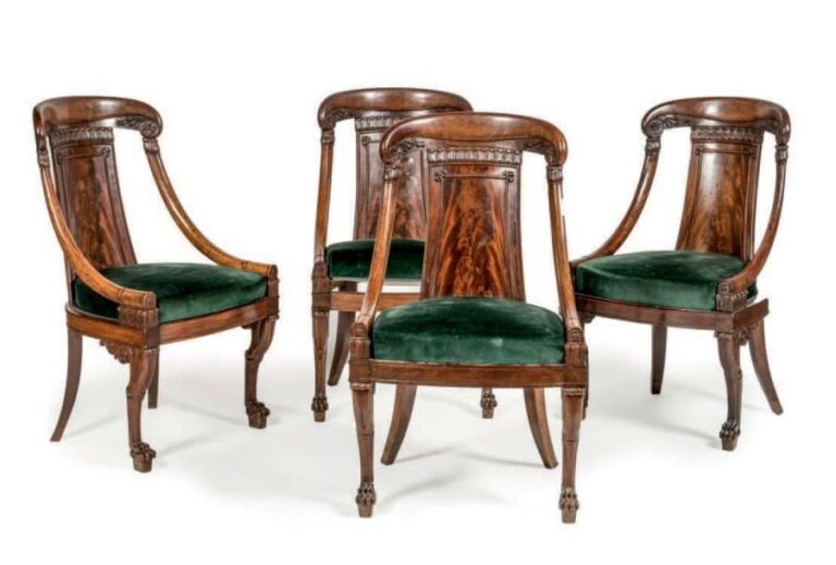 Suite de quatre fauteuils à dossier gondole en acajou et ronce d'acajou; les dossiers agrémentés de motifs sculptés; pieds en jarret de félin à l'avant et sabres à l'arrièr