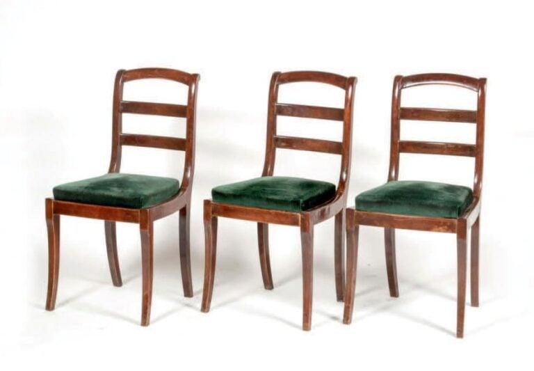 Suite de trois chaises en acajou et placage d'acajou à dossiers barrettes légèrement renversés; pieds sabre
